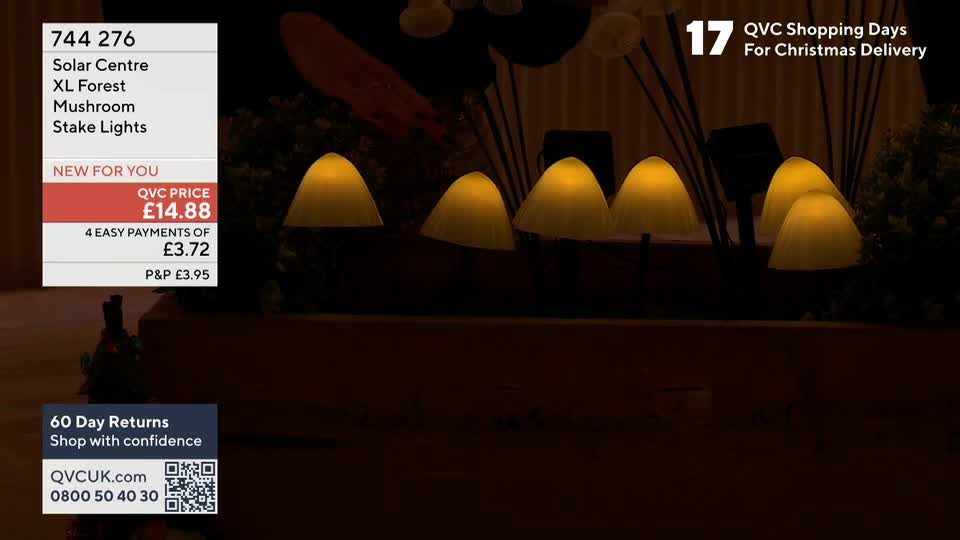 A row of mushroom-shaped lights glows against a dark backdrop, presumably for a QVC Extra segment. The price is displayed on the screen, and it's "New for You" at £14.88.
