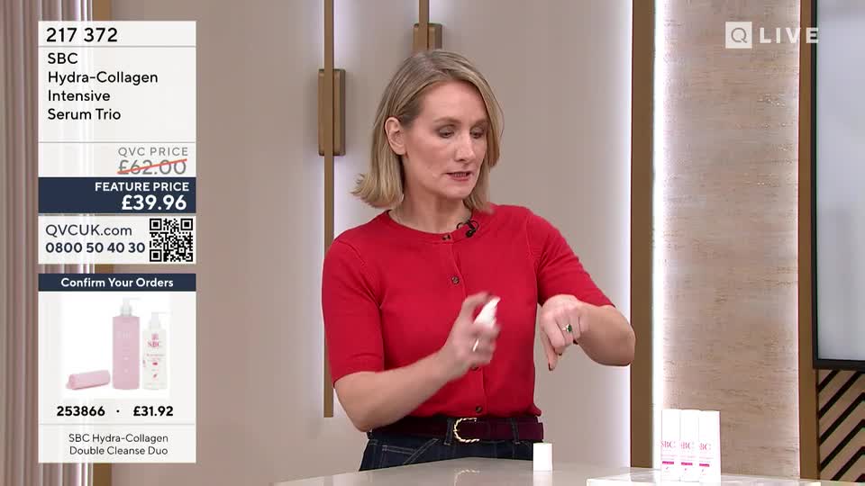 A woman in a red top sprays a product onto her wrist. On the screen, the QVC Extra logo is visible, along with pricing for a serum trio. A woman in a red top sprays a product onto her wrist. On the screen, the QVC Extra logo is visible, along with pricing for a serum trio.