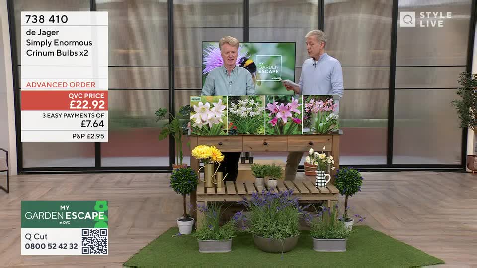 Two men stand behind a wooden display table, presenting images of large, colourful bulbs. On the left, a graphic advertises "Simply Enormous Crinum Bulbs x2" for £22.92. Two men stand behind a wooden display table, presenting images of large, colourful bulbs. On the left, a graphic advertises "Simply Enormous Crinum Bulbs x2" for £22.92.