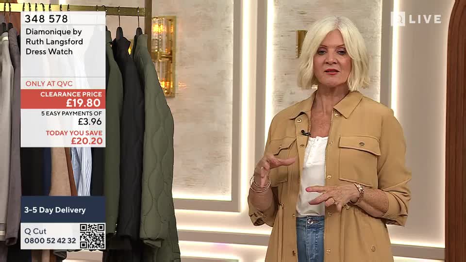 A woman with blonde hair gestures towards a rack of jackets, describing something on a television shopping channel. The screen displays product details and a clearance price.
