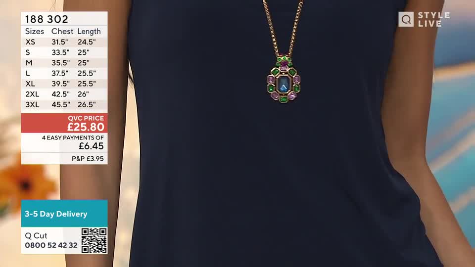 A woman is wearing a navy top, and a colourful pendant hangs on a gold chain. The QVC price and sizing details are displayed to the left of the model.
