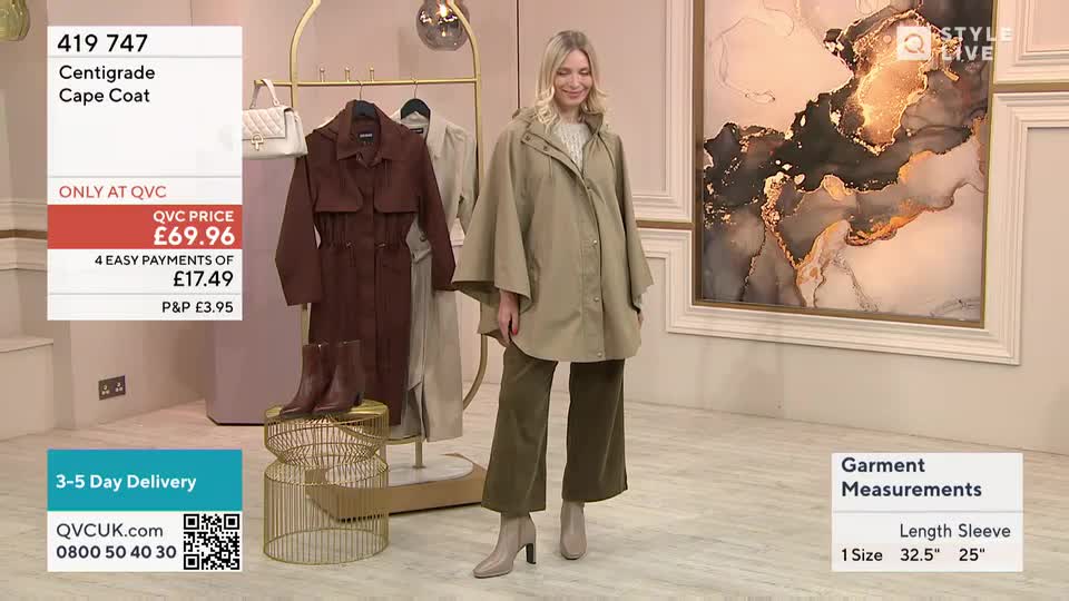 A woman in a tan cape coat stands center stage, smiling as she models the garment. Behind her, a rack displays two other coats, and a screen shows the price and payment options.
