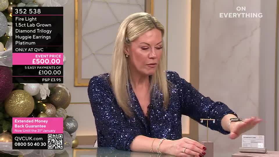 A woman in a sparkly blue jacket gestures toward a pair of earrings on a small stand, while talking about them on a QVC-style broadcast. The price of the earrings, £500, is displayed on the screen.
A woman in a sparkly blue jacket gestures toward a pair of earrings on a small stand, while talking about them on a QVC-style broadcast. The price of the earrings, £500, is displayed on the screen.