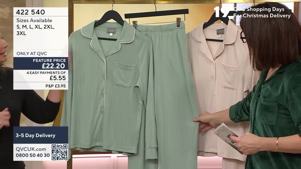 A presenter in a green velvet top holds a small card while pointing at a pair of pale green pyjamas. The camera focuses on the sleepwear hanging on a rail alongside a beige set, with details about the price and sizes displayed on screen.
A presenter in a green velvet top holds a small card while pointing at a pair of pale green pyjamas. The camera focuses on the sleepwear hanging on a rail alongside a beige set, with details about the price and sizes displayed on screen.