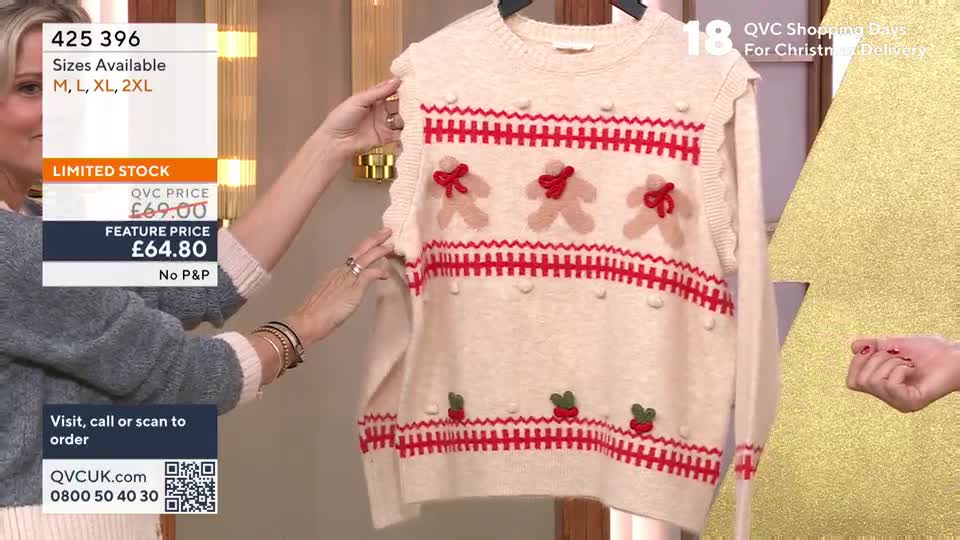 A woman is holding up a cream-colored sweater with red gingerbread men and trim, showing it off to the camera. The price is displayed on a screen in the corner, and the presenter is discussing the item on a QVC-style shopping show.
A woman is holding up a cream-colored sweater with red gingerbread men and trim, showing it off to the camera. The price is displayed on a screen in the corner, and the presenter is discussing the item on a QVC-style shopping show.