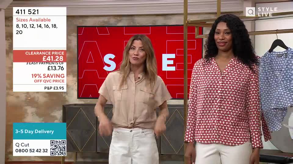 Two women stand on a brightly lit set, presenting clothing. The woman on the left gestures with her hands while the woman on the right smiles.