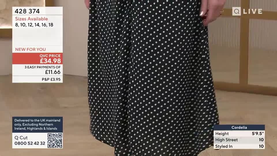 A woman twirls, her black polka-dot dress flaring out. On-screen text displays the item's price and available sizes, a common sight during a QVC broadcast.