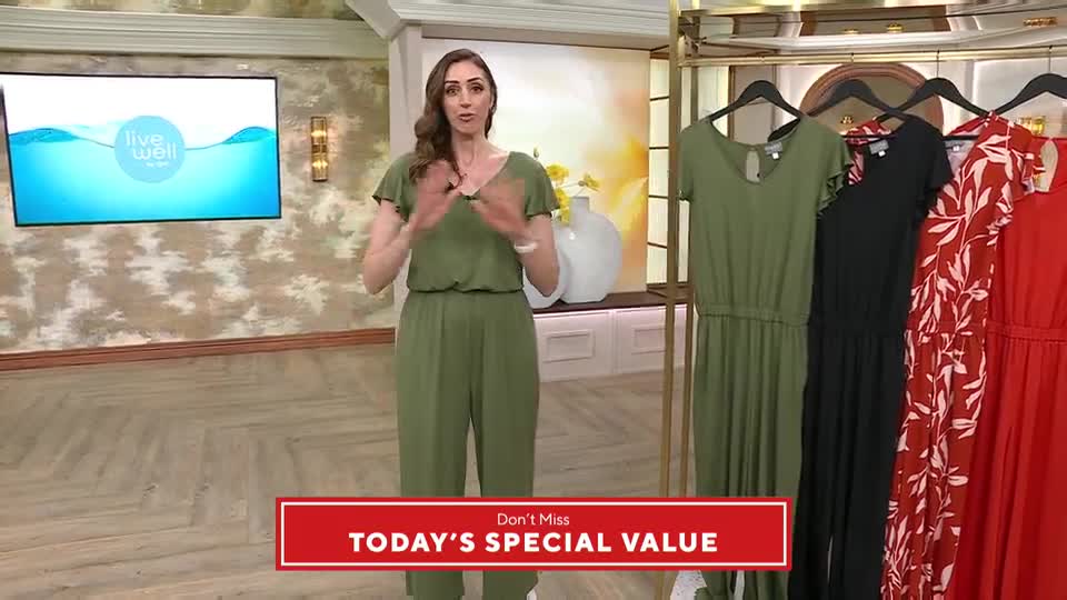 A woman in a green jumpsuit gestures as she stands next to a rack of colourful jumpsuits, all part of a "Today's Special Value" offer. The presentation is happening live, likely for a UK audience.