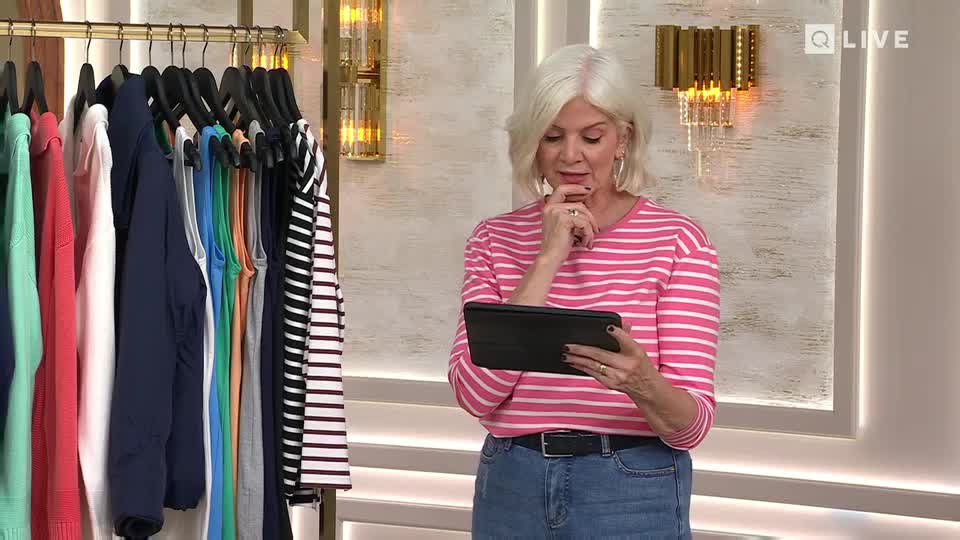 A rack of colourful clothes hangs to the left, and a woman in a pink and white striped top examines a tablet. She's holding her chin, deep in thought.