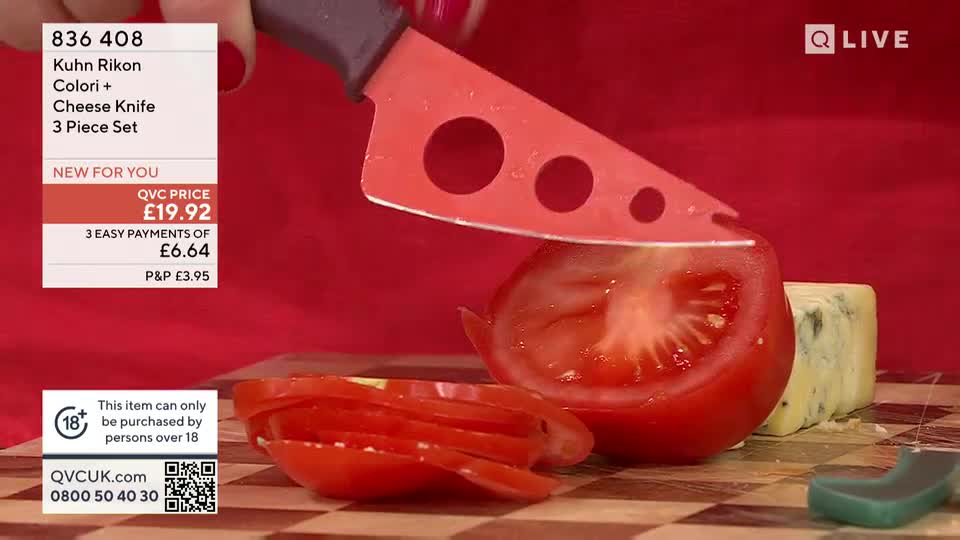 A red cheese knife, with holes in the blade, slices through a tomato on a cutting board. The QVC UK logo is visible, along with the price of the knife set.
