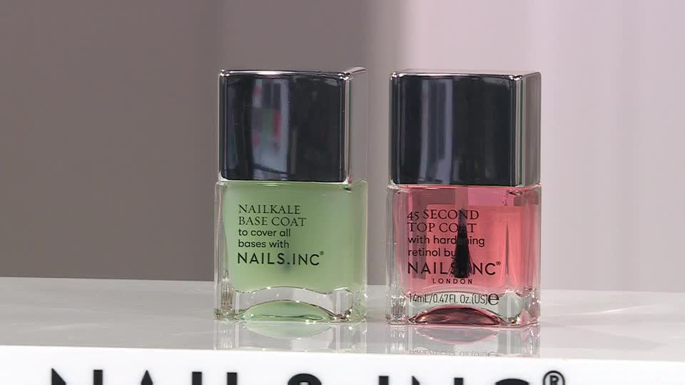 Two bottles of Nails.Inc nail polish sit side-by-side. The one on the left contains a pale green base coat, while the right bottle holds a sheer pink top coat.