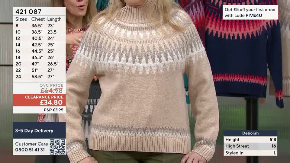 A woman stands in a beige jumper with a fair isle pattern around the neck. Another jumper, navy with a pink and red pattern, hangs on a stand to her right. A woman stands in a beige jumper with a fair isle pattern around the neck. Another jumper, navy with a pink and red pattern, hangs on a stand to her right.