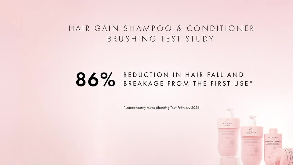 A large "86%" dominates the screen, followed by text stating "REDUCTION IN HAIR FALL AND BREAKAGE FROM THE FIRST USE." Several bottles of what appears to be shampoo and conditioner stand in a row at the bottom right.