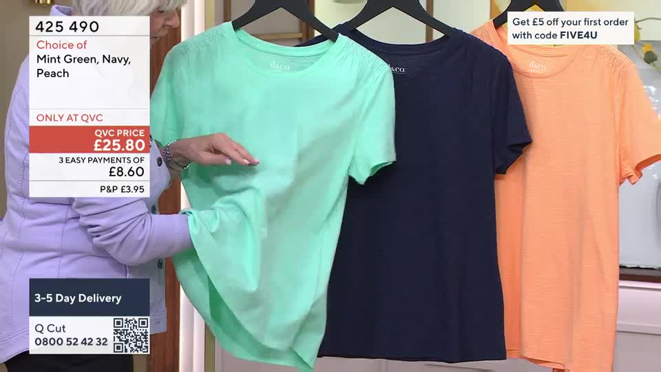 A woman's hand gently smooths a mint green t-shirt hanging on a rack. Next to it, a navy blue and an orange t-shirt are also displayed, ready for purchase. A woman's hand gently smooths a mint green t-shirt hanging on a rack. Next to it, a navy blue and an orange t-shirt are also displayed, ready for purchase.