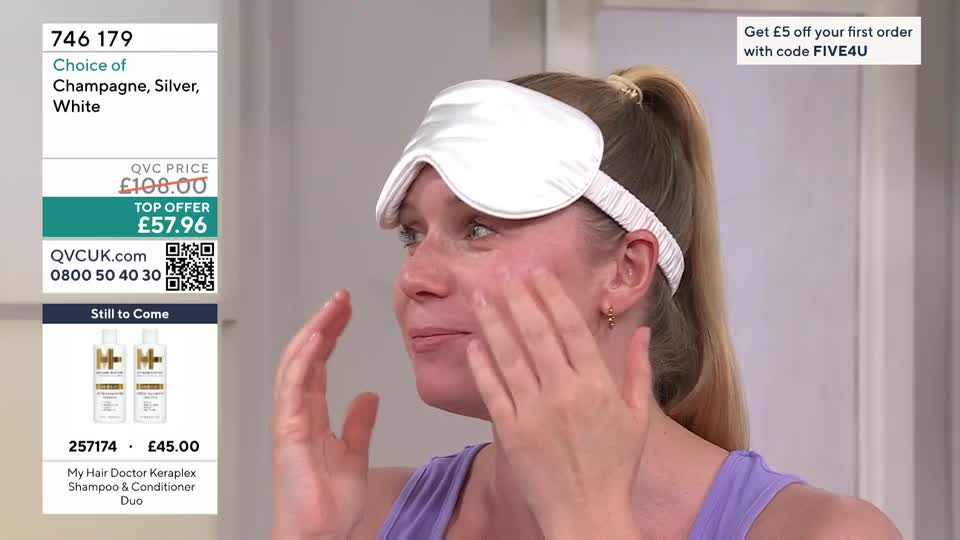 A woman with a white sleep mask across her eyes gently massages cream into her cheeks. On the left, a graphic displays a QVC offer for a shampoo and conditioner duo. A woman with a white sleep mask across her eyes gently massages cream into her cheeks. On the left, a graphic displays a QVC offer for a shampoo and conditioner duo.