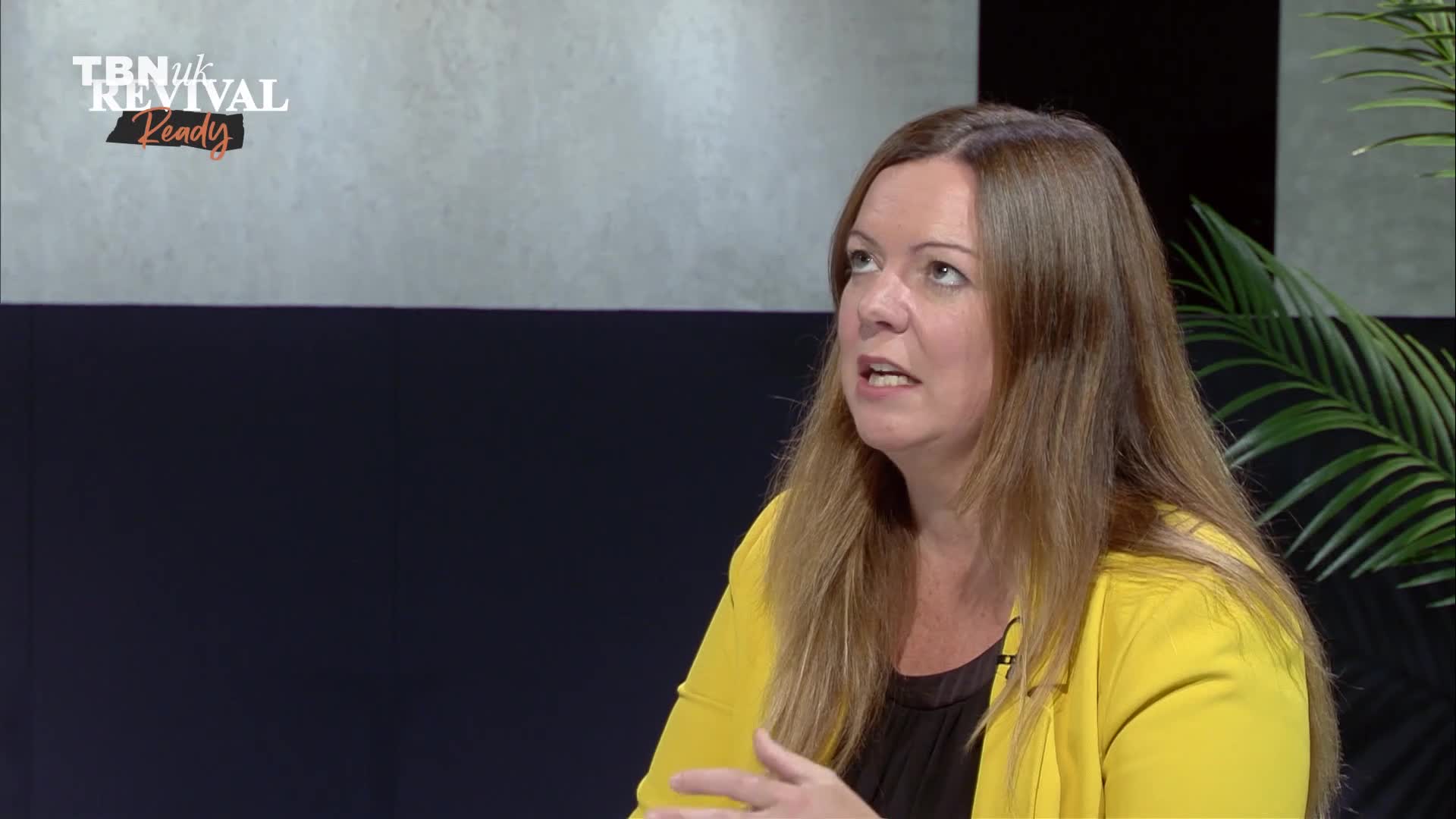 A woman with long, light brown hair gestures with her right hand as she speaks. The TBN UK logo is visible in the upper left corner.
