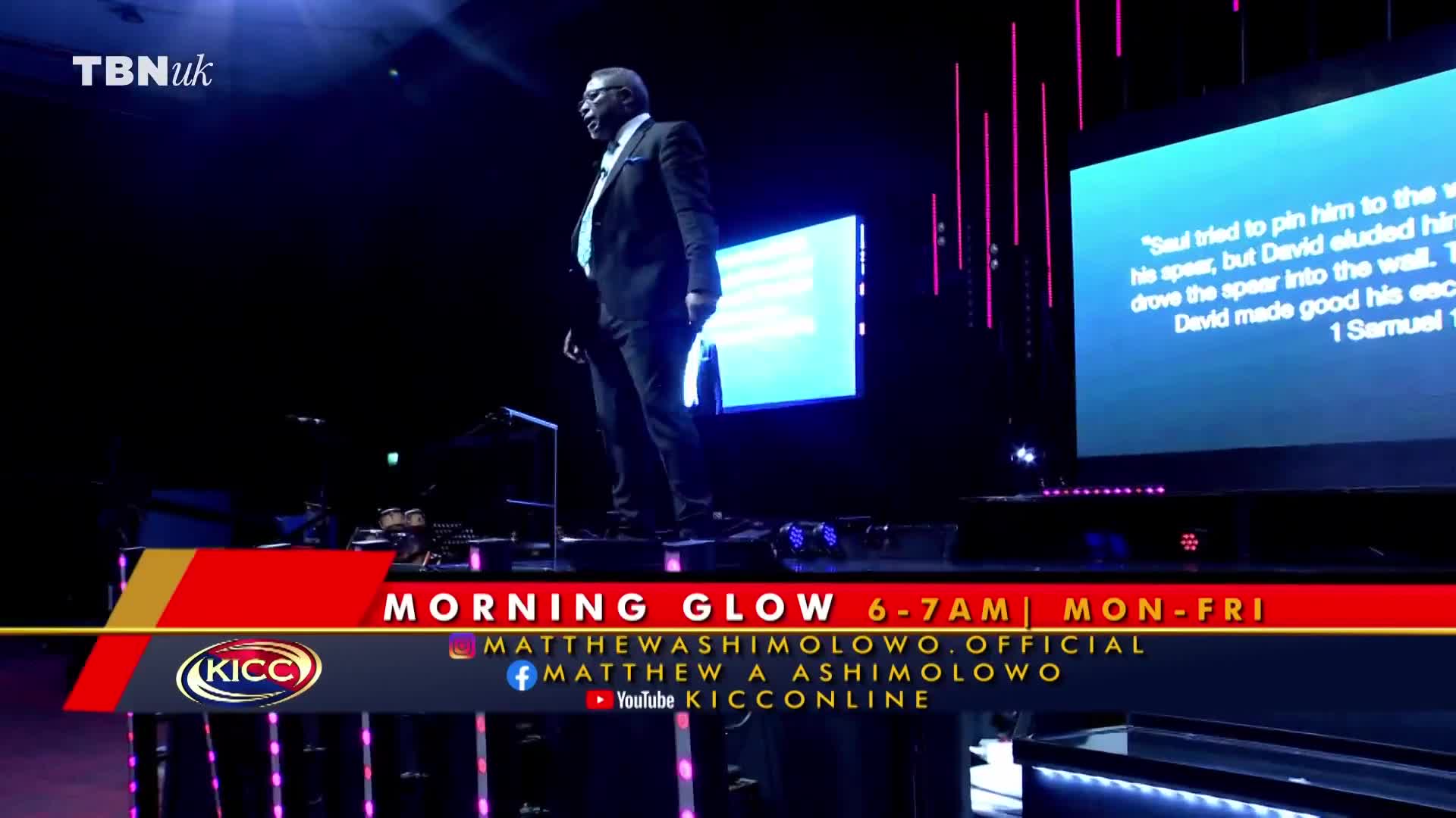 A man in a suit stands on a stage, illuminated by spotlights. Behind him, a screen displays text, and the lower third of the screen shows details for "Morning Glow" on TBN UK.
A man in a suit stands on a stage, illuminated by spotlights. Behind him, a screen displays text, and the lower third of the screen shows details for "Morning Glow" on TBN UK.