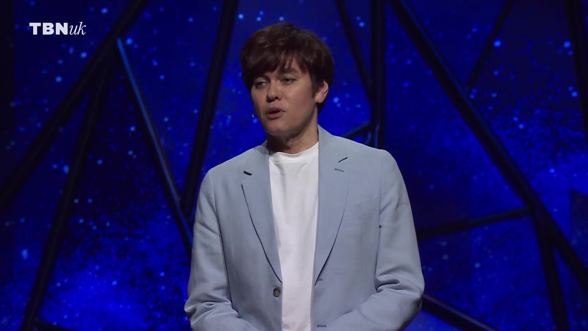 A man in a light blue jacket and white shirt stands on a stage. The TBN UK logo is visible in the corner against a dark blue backdrop.
A man in a light blue jacket and white shirt stands on a stage. The TBN UK logo is visible in the corner against a dark blue backdrop.