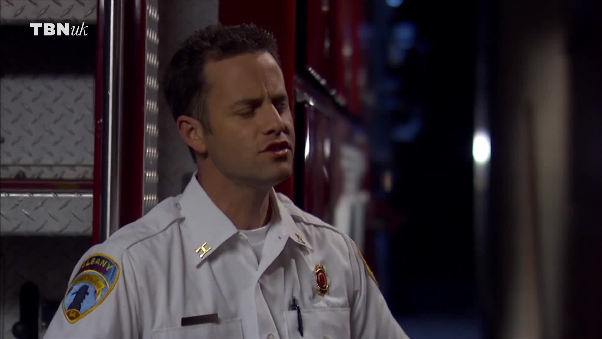 A man in a white uniform, likely a first responder, is speaking, his eyes closed. Behind him, a red vehicle is parked, and the TBN UK logo is visible in the corner.
A man in a white uniform, likely a first responder, is speaking, his eyes closed. Behind him, a red vehicle is parked, and the TBN UK logo is visible in the corner.