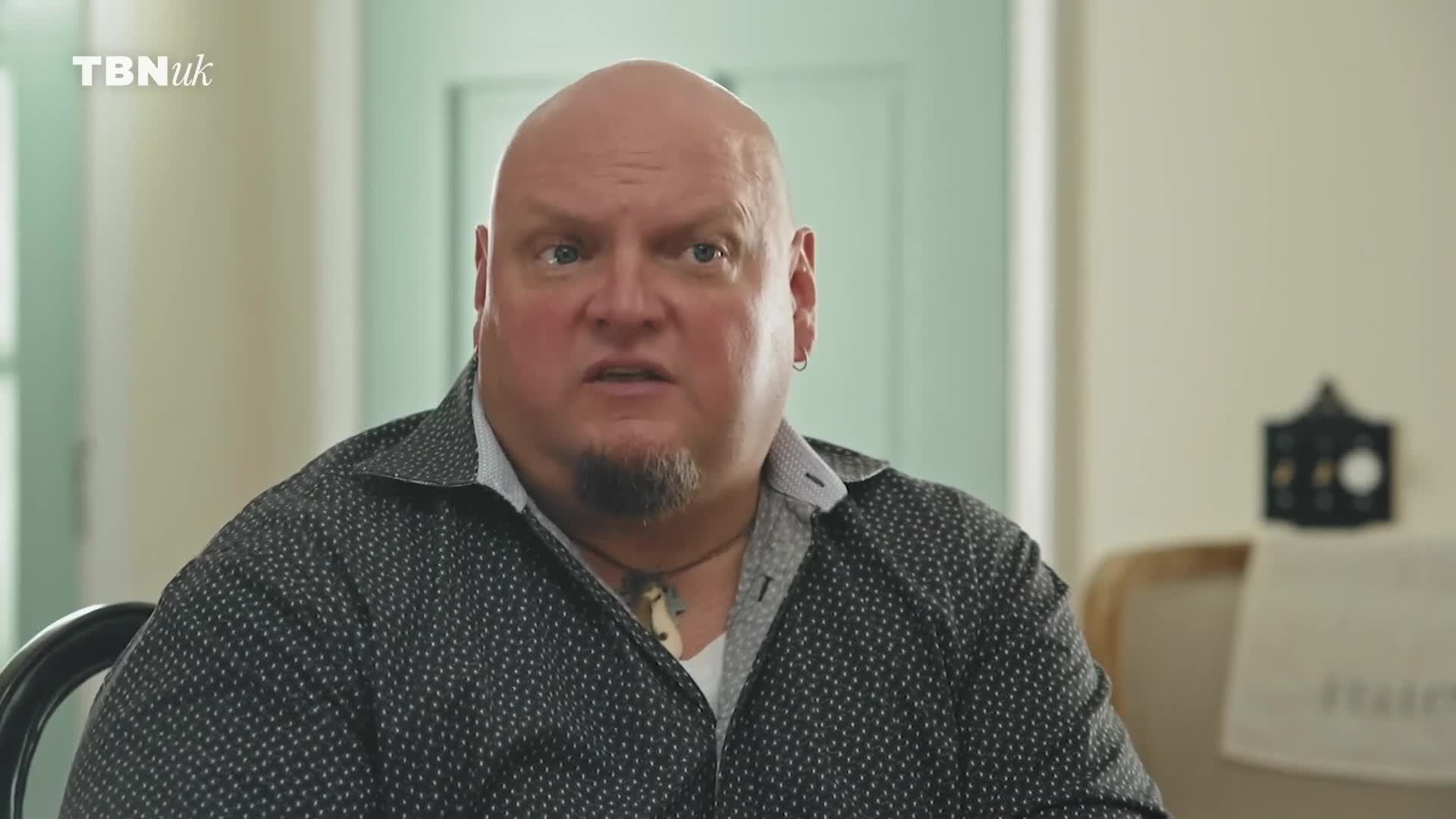 A man with a shaved head and goatee is speaking, his expression intense. The TBN UK logo is visible in the corner.
A man with a shaved head and goatee is speaking, his expression intense. The TBN UK logo is visible in the corner.