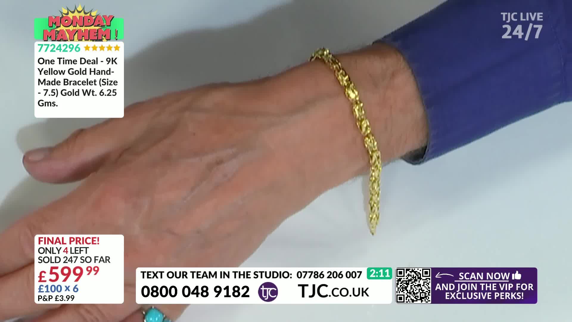 A gold bracelet, linked in a textured pattern, rests on a wrist. The presenter's hand is still, drawing attention to the gleaming jewelry.
