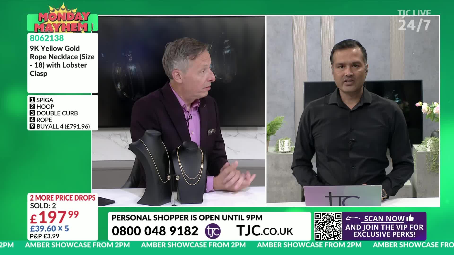 Two men are on set, discussing jewelry for sale on TJC. One gestures towards the necklaces displayed on black stands, while the other speaks directly to the camera.
