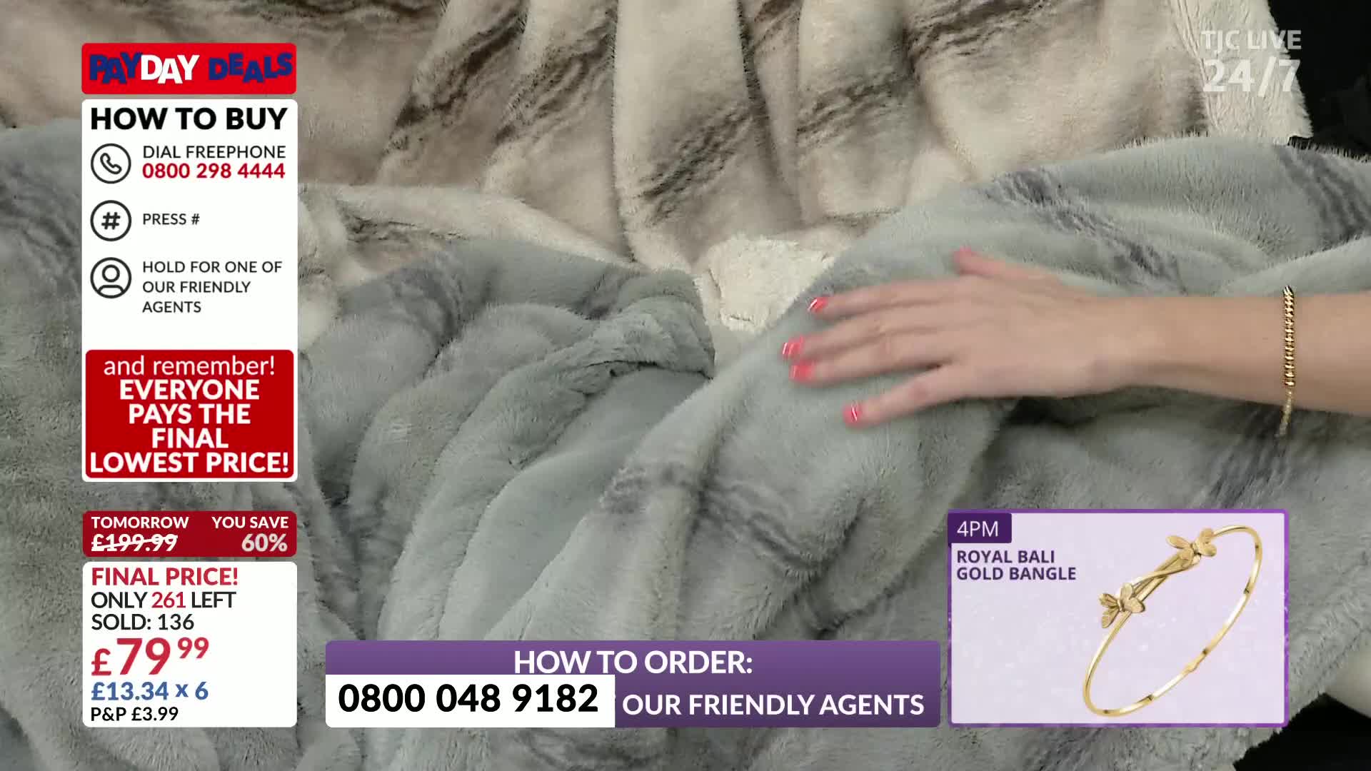 A hand with painted nails strokes a soft, grey blanket on a TJC live shopping segment. Graphics flash on screen, advertising a "Payday Deal" from the United Kingdom.
