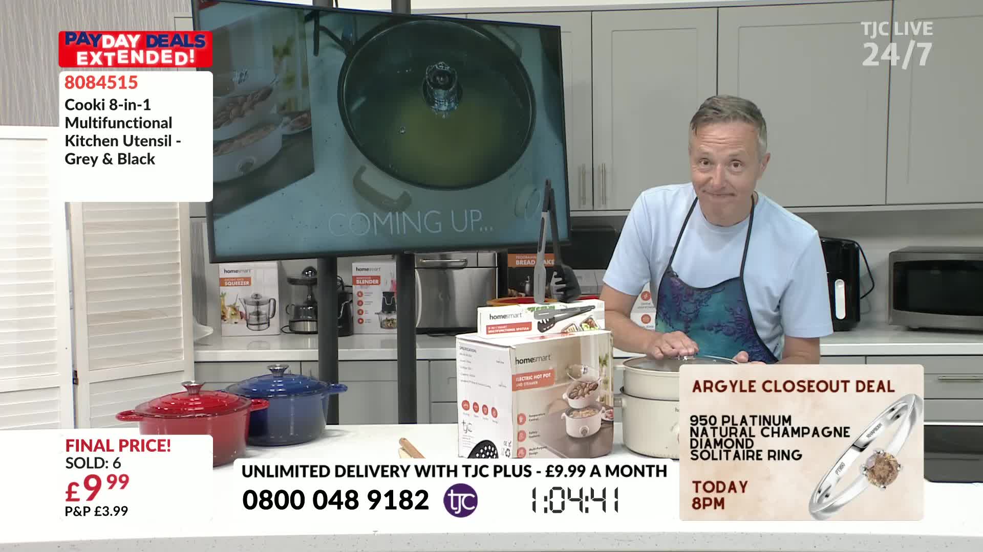 A man in an apron stands behind a countertop, lifting the lid off a small, cream-colored pot. The screen behind him displays a close-up of a cooking utensil, and the on-screen text advertises a "Pay Day Deal" from TJC.
