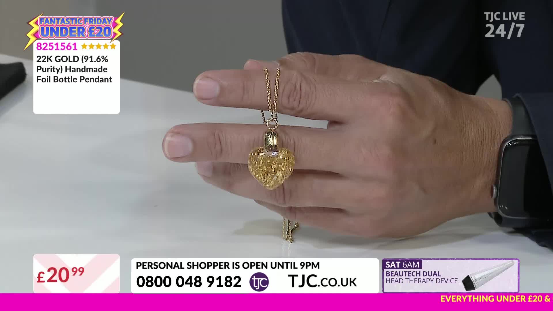 A gold heart-shaped pendant hangs from a delicate chain, held between the presenter's fingers. The TJC host displays the necklace, its foil-filled heart sparkling under the studio lights.
