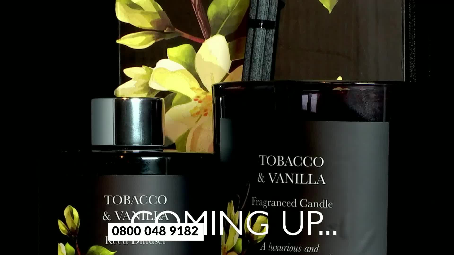 A reed diffuser and a candle, both labeled "Tobacco & Vanilla," are set against a dark backdrop. The words "COMING UP..." appear, along with a phone number.
