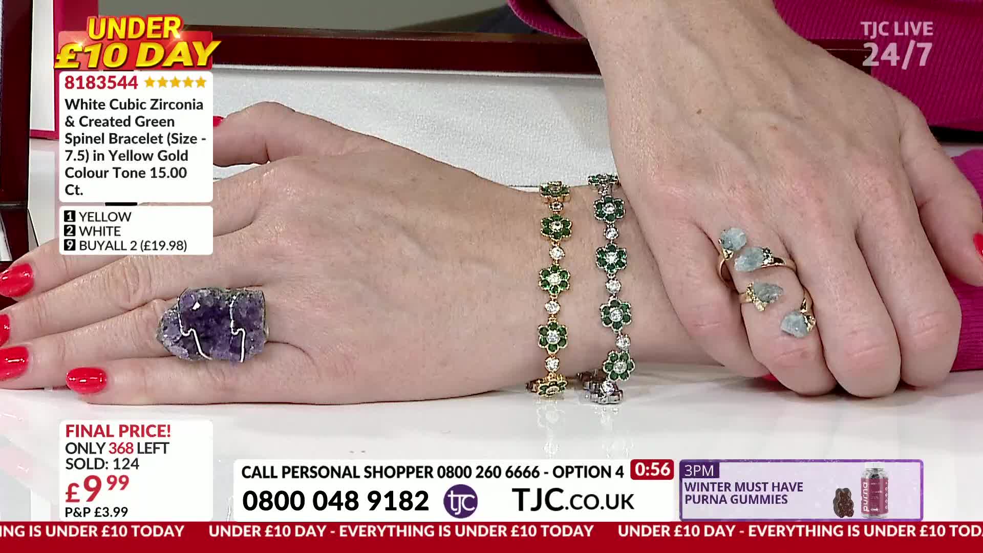 A hand displays several pieces of jewelry, including a large purple stone ring and two flower-shaped bracelets. The presenter, on a TJC show, is showing off the items, with the price and product details displayed on a screen.
