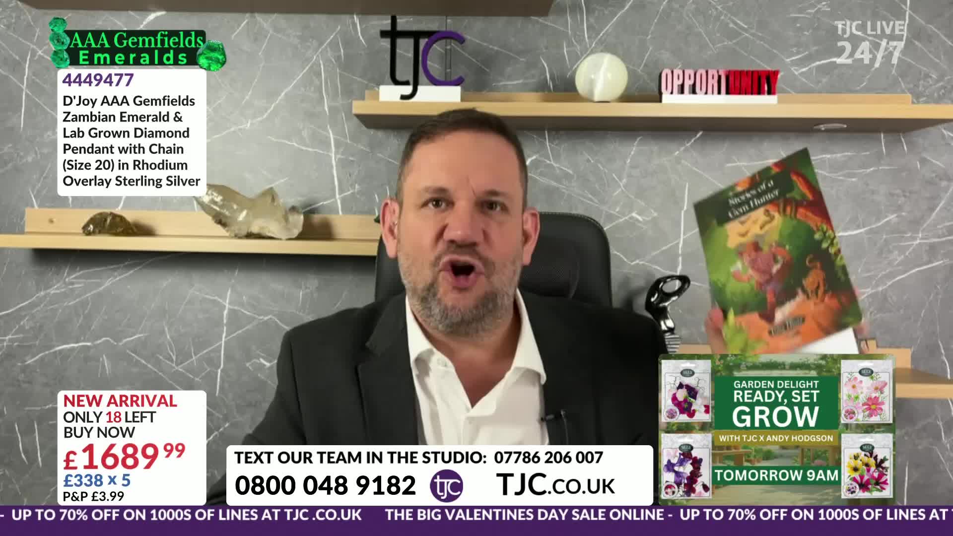 The presenter gestures emphatically while a book titled "Secrets of a Corn Hunter" tilts precariously on a shelf behind him. A display for "Garden Delight: Ready, Set, Grow" sits below, featuring seed packets.