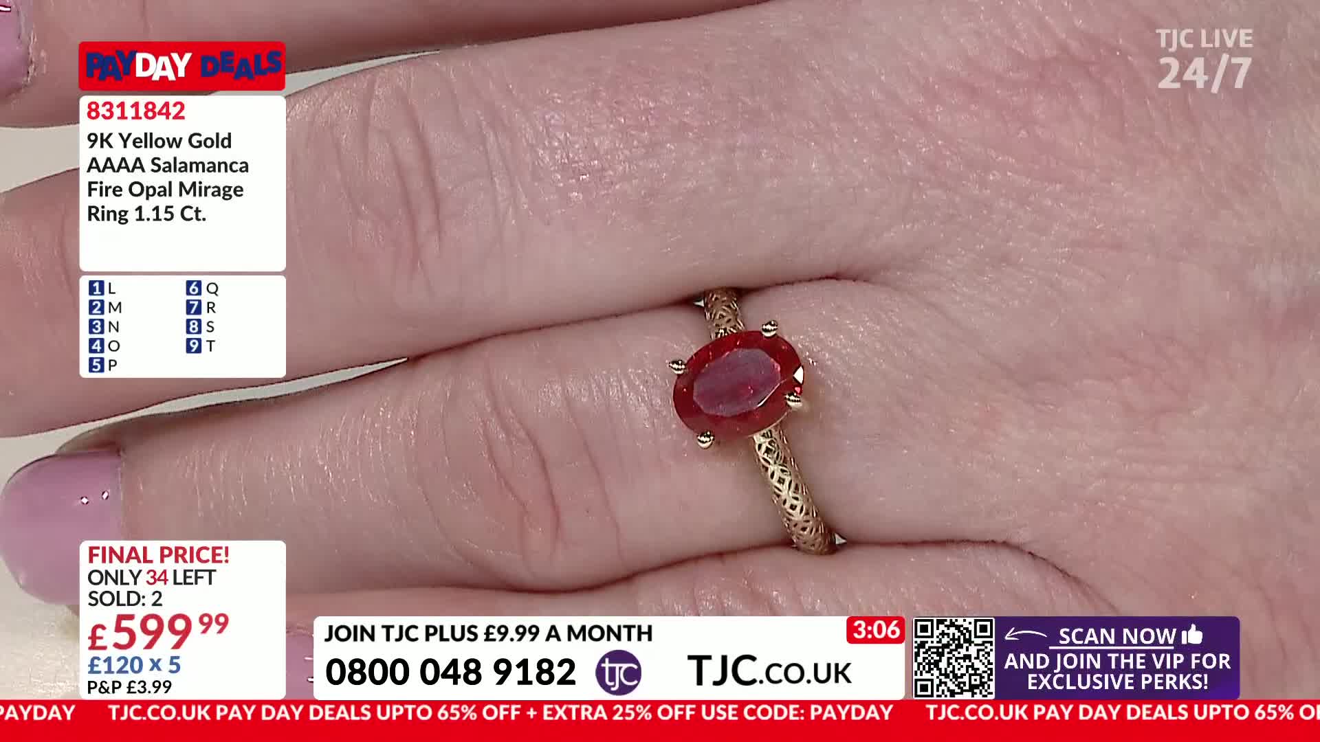 A hand displays a gold ring with a deep red oval stone. The band has a textured pattern, and the stone catches the light.