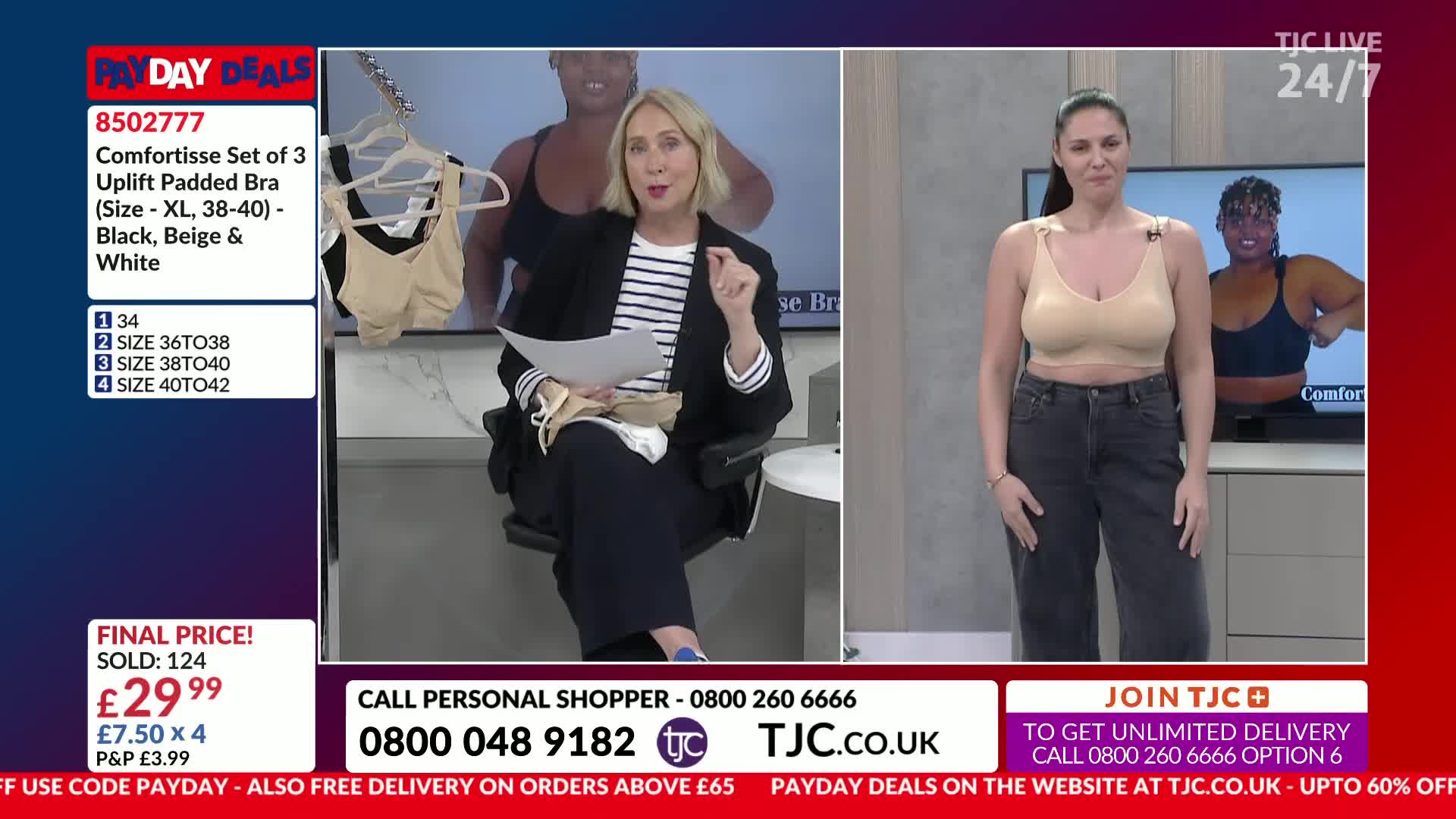 A woman stands in a beige bra and dark jeans, while another woman in a blazer sits and gestures. On a screen behind them, another woman models a black bra.