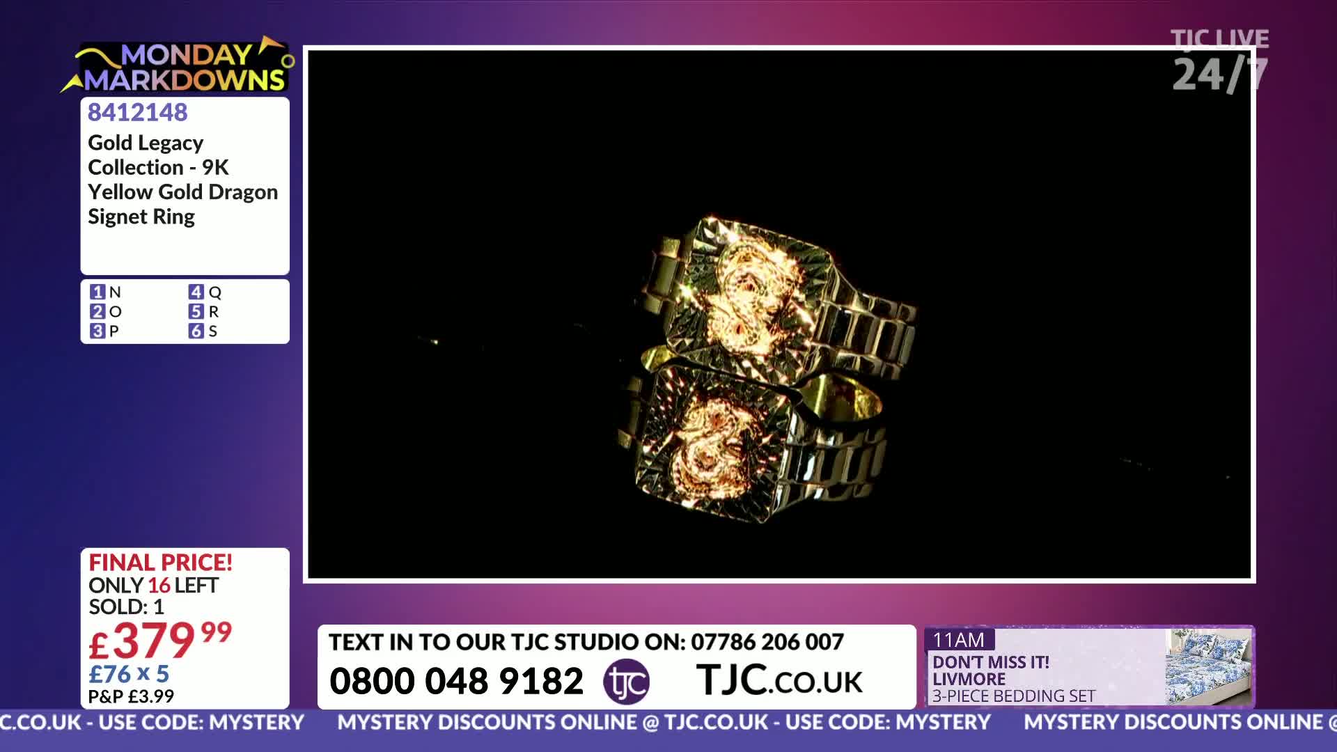 A gold signet ring with a dragon design sits on a reflective surface. The ring's band resembles watch links.