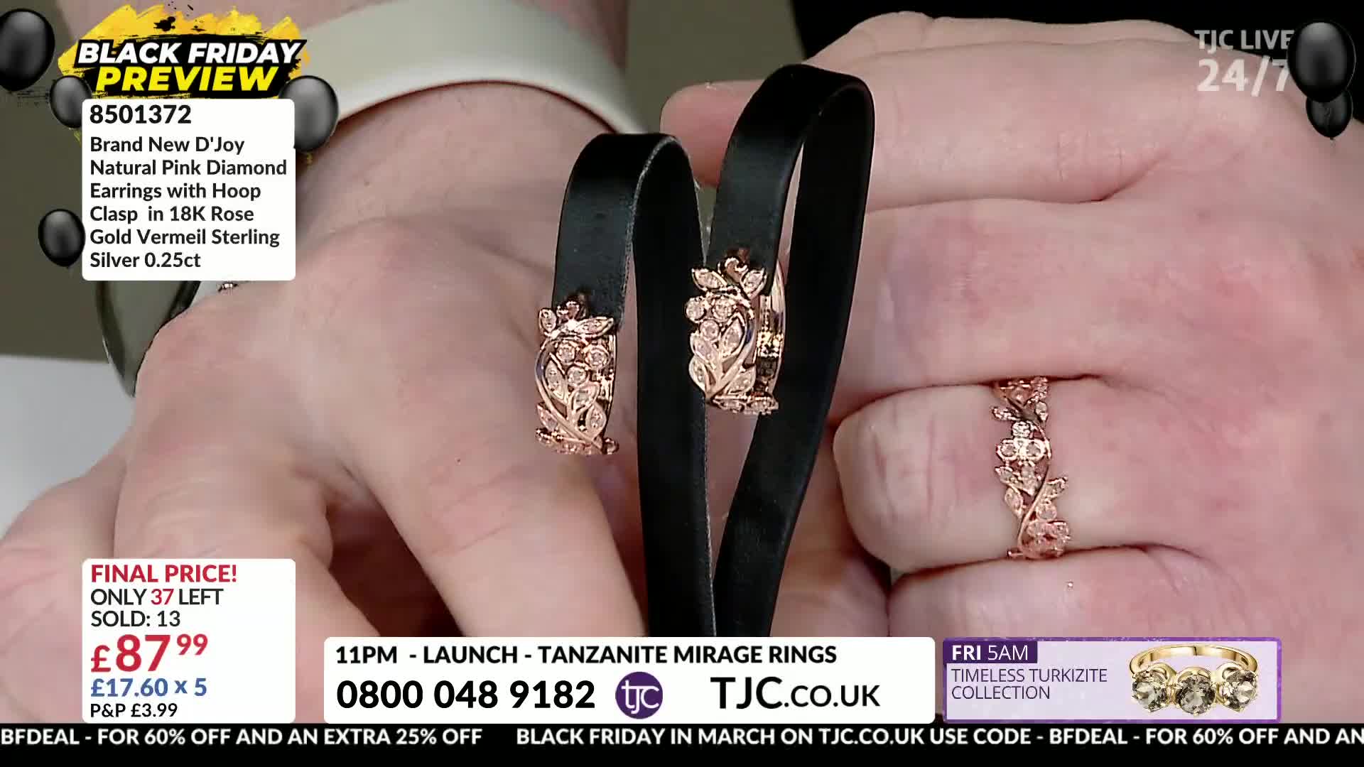 A pair of rose gold earrings, each adorned with small diamonds, rests on a black display. A matching ring, also featuring delicate floral designs and tiny stones, sits on a finger.