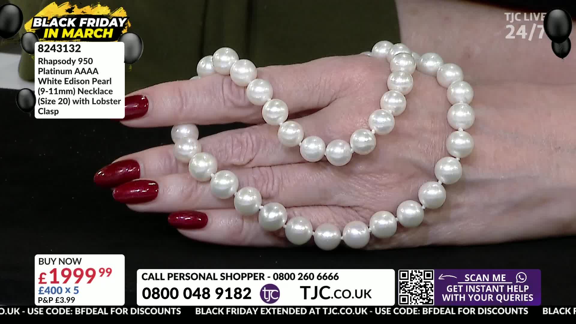 A hand with dark red nail polish drapes a strand of luminous white pearls. The necklace, a platinum Rhapsody 950 with Edison pearls, is displayed on TJC.
