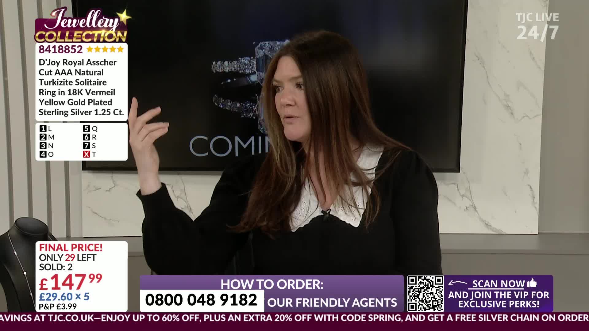 A woman on TJC Live gestures animatedly while a display of jewellery sits on a stand to her left. The screen behind her shows the word "COMING" in large letters.