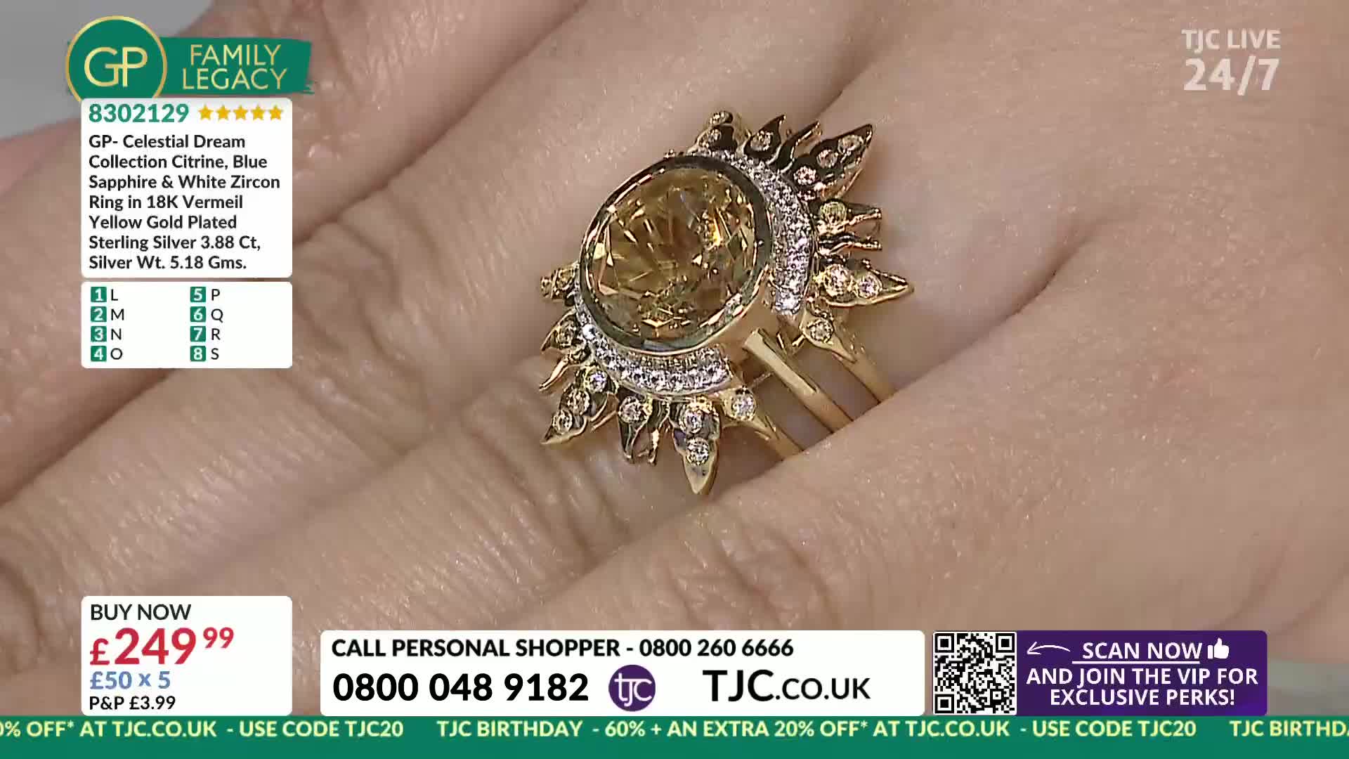 A hand displays a large, sun-shaped ring with a yellow gemstone. The ring's gold setting features small, sparkling stones around its perimeter.