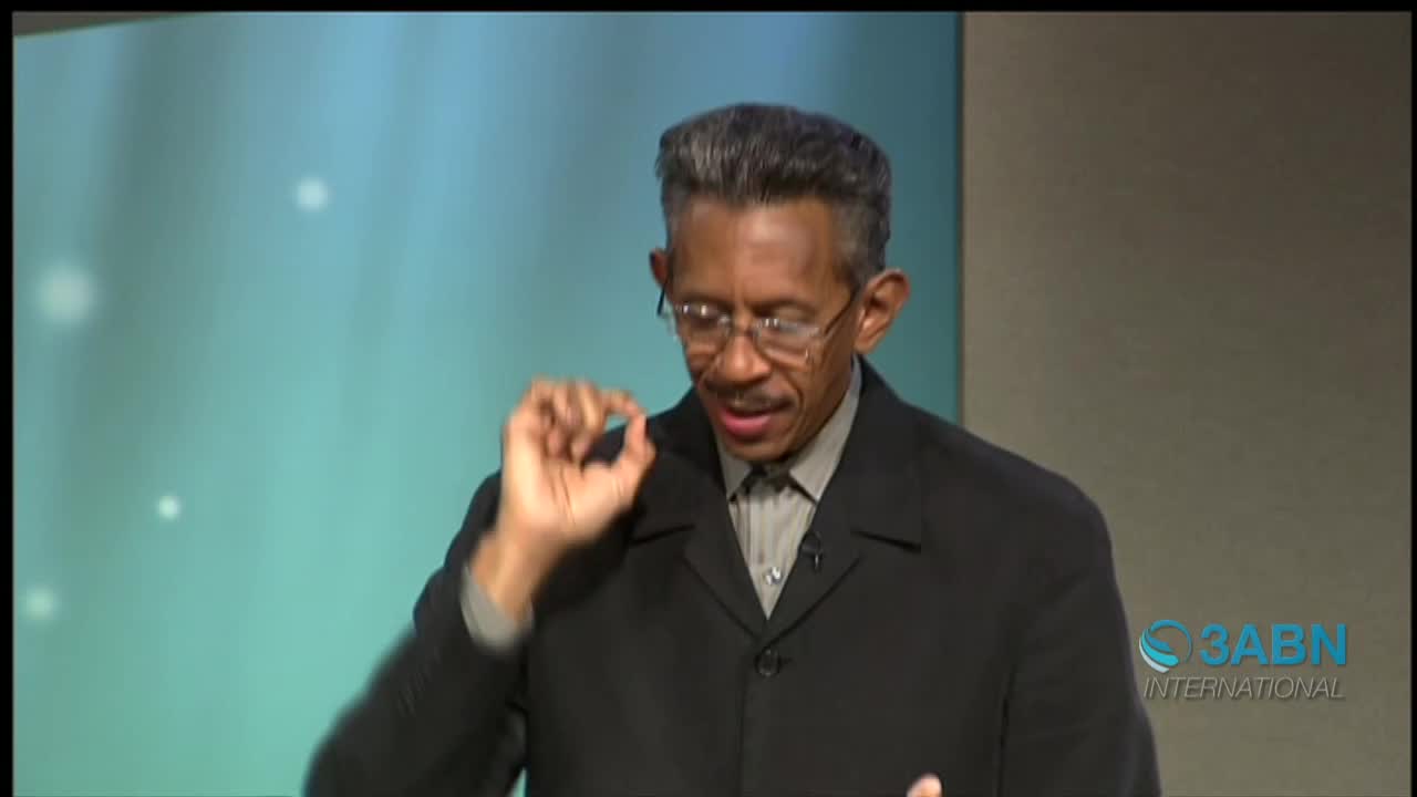 The man in the suit gestures with his right hand, his fingers pinched together. He speaks on the set of 3ABN International, a television ministry based in the United States.
