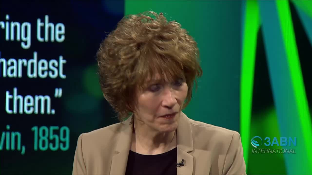 A woman in a tan blazer is speaking, her expression serious. Behind her, the 3ABN International logo is visible on a green backdrop, and text from a quote is partially visible.
