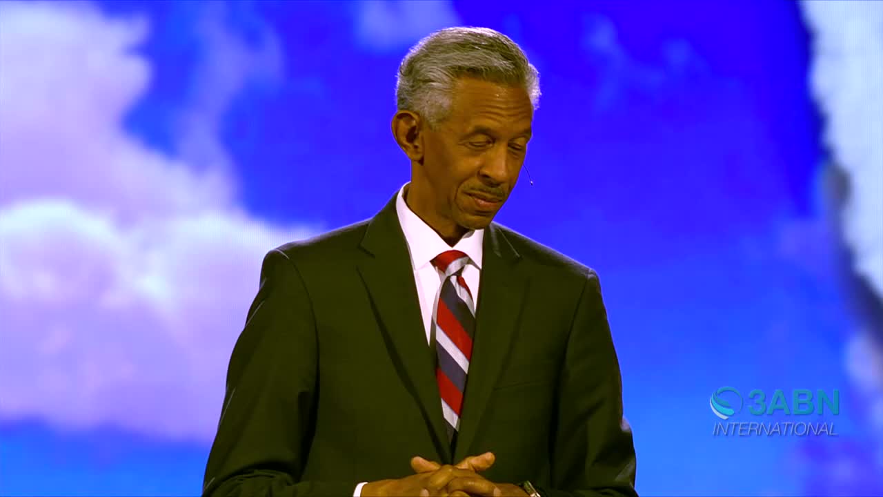 A man in a dark suit stands with his hands clasped, looking down. The 3ABN International logo is visible on the right side of the screen.
