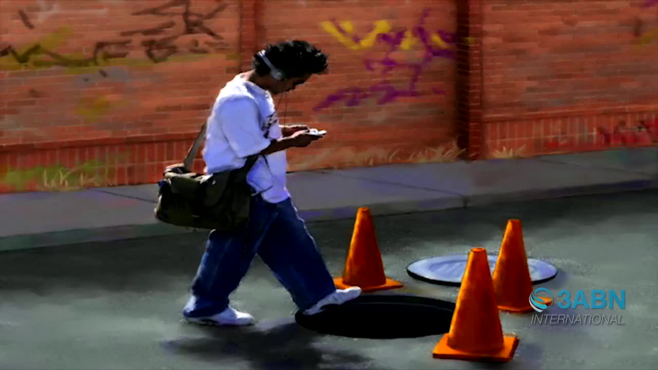 A young man, headphones on, walks down the sidewalk, eyes fixed on his phone. He's stepping over an open manhole, with orange cones warning him of the hazard.
