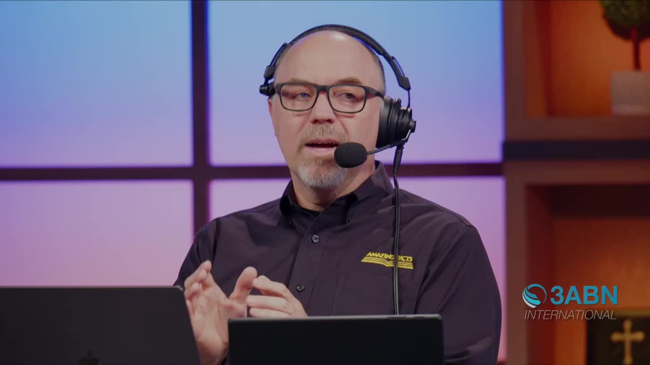 A man wearing a headset and glasses gestures with his hands as he speaks into a microphone. The 3ABN International logo is visible on the right side of the screen.
