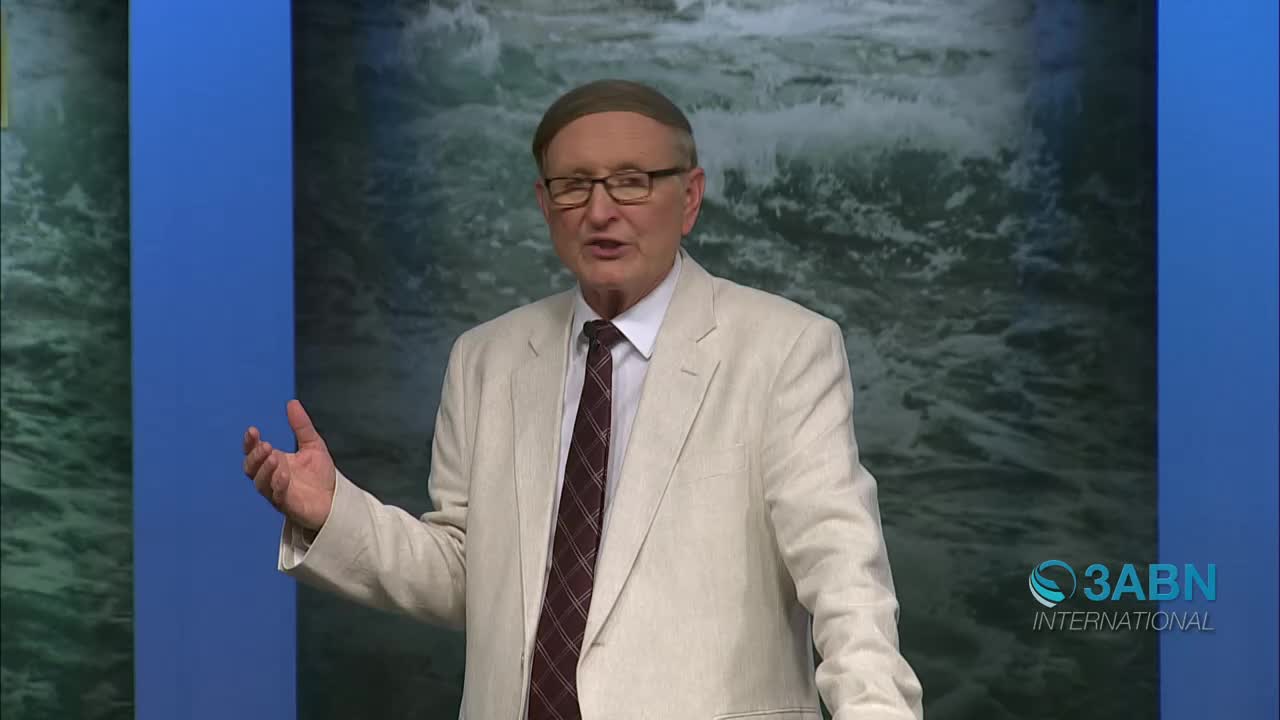 A man in a light suit and striped tie speaks with his hands gesturing. A logo for 3ABN International appears in the lower right corner.