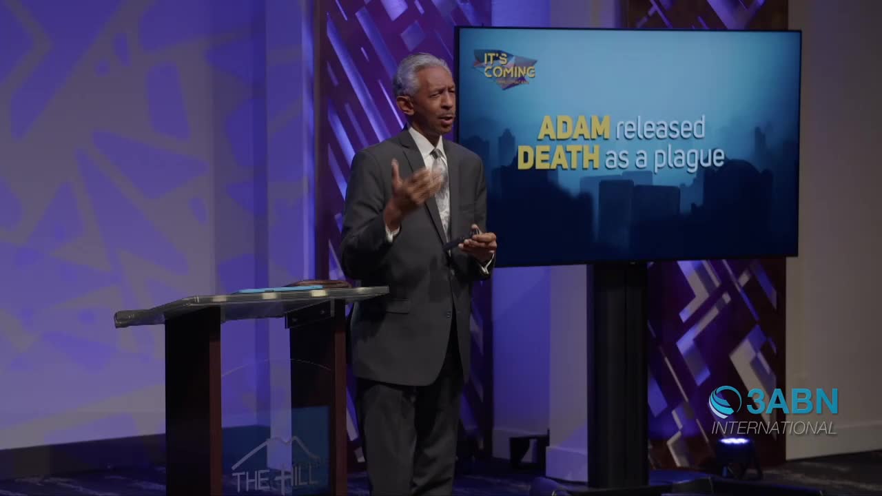 A man in a suit stands at a podium, gesturing with his hands. Behind him, a large screen displays text that reads "ADAM released DEATH as a plague." The 3ABN International logo appears in the lower right corner.