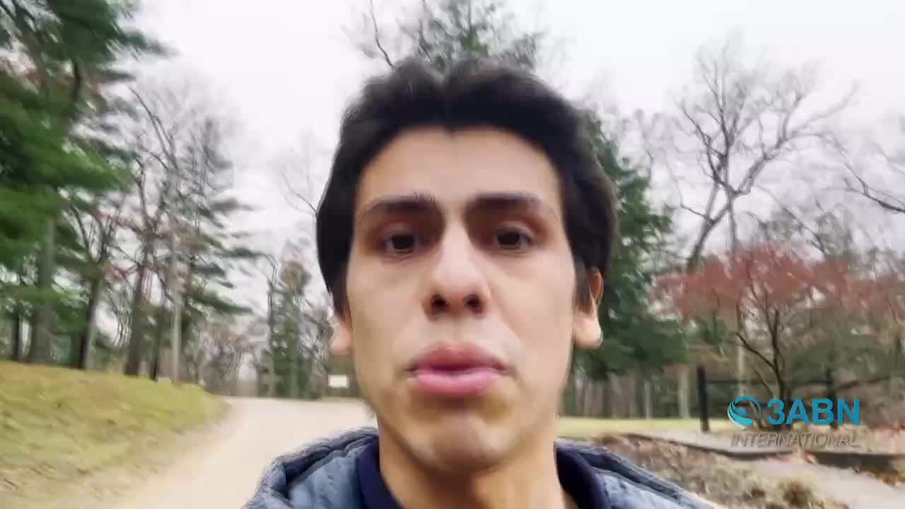 A young man walks down a dirt path in a park, the trees bare against a cloudy sky. The 3ABN International logo appears in the lower right corner.