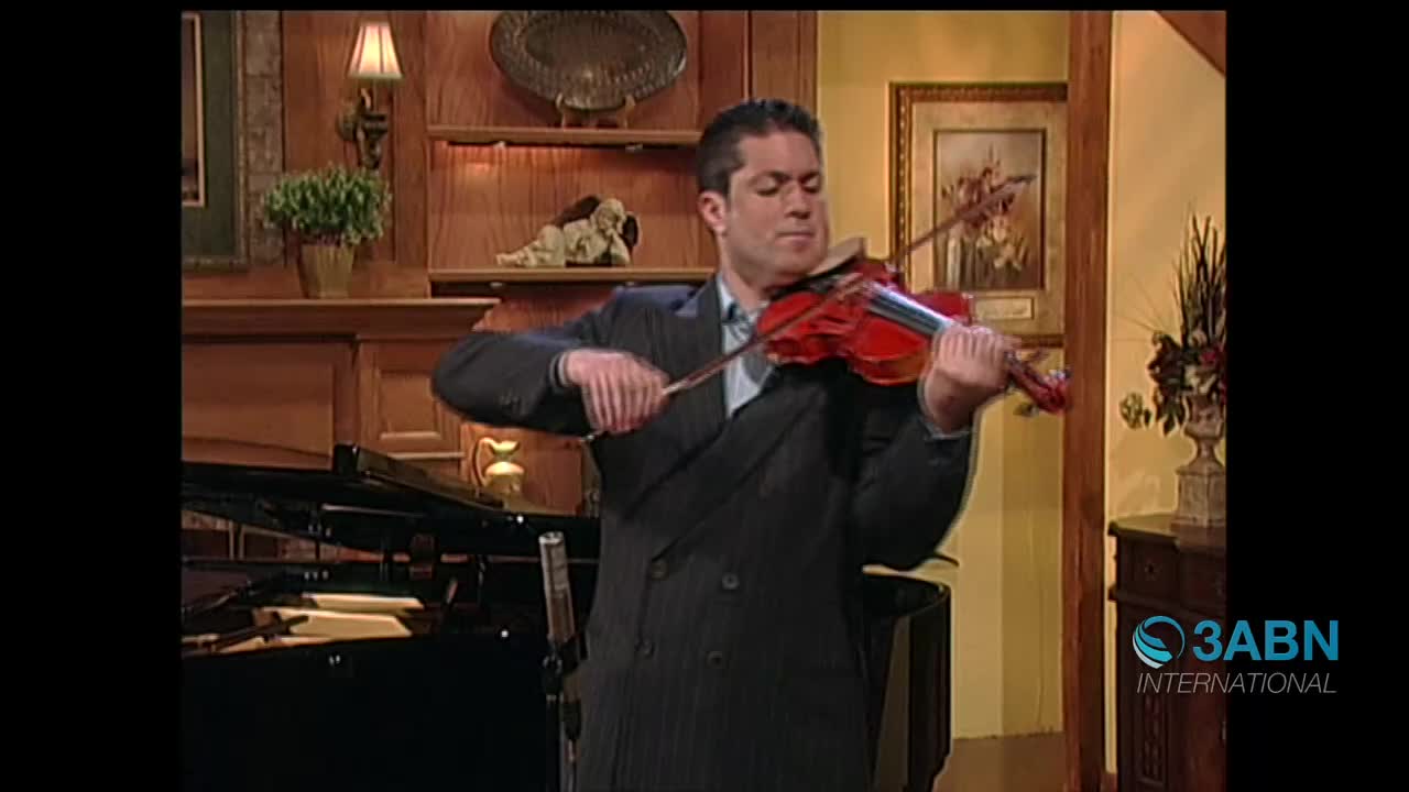 A man in a pinstripe suit plays a violin, his bow moving across the strings. The 3ABN International logo appears in the lower right corner.