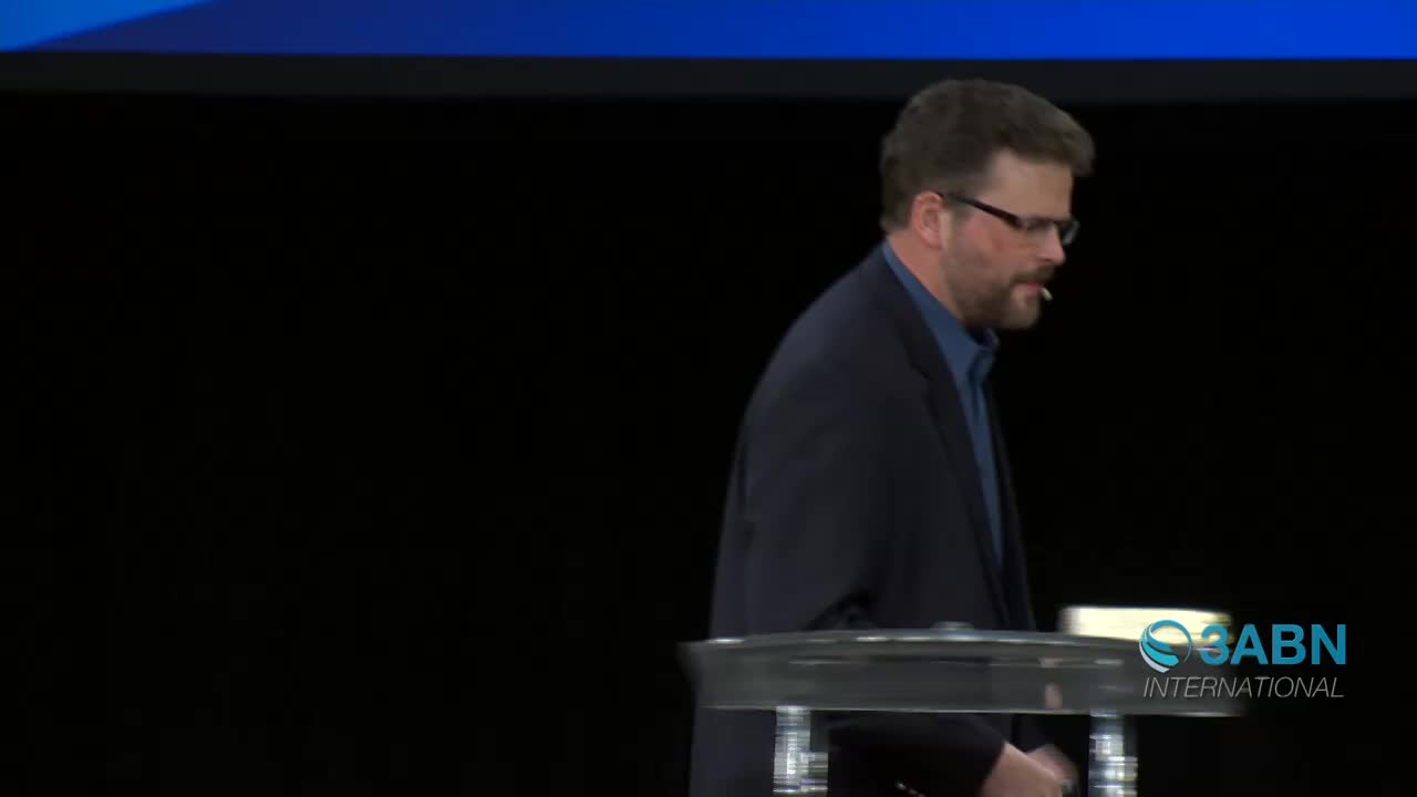 A man in a dark suit walks past a clear podium. The 3ABN International logo appears on the right side of the screen.