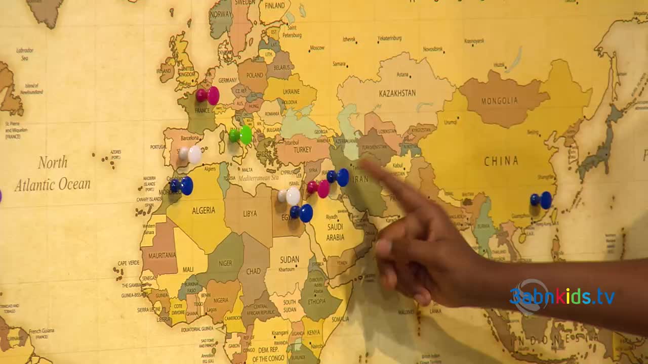 A hand points at a map, highlighting various locations with colorful push pins. The 3ABN Kids logo is visible, suggesting a geography lesson or travel-themed segment is underway.
